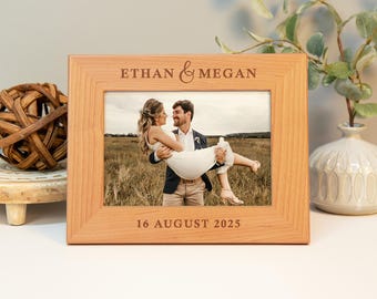 May include: A wooden picture frame with a photo of a couple. The frame is engraved with the text "Ethan & Megan" and "16 August 2025".