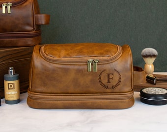 May include: Brown leather travel toiletry bag with a zipper closure and a monogrammed initial "F" on the front.