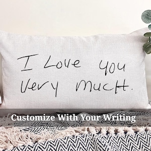 May include: A white pillow with the handwritten message "I love you very much." on it. The pillow is on a black and white patterned surface.