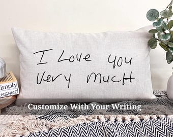 May include: A white pillow with the handwritten message "I love you very much." on it. The pillow is on a black and white patterned surface.