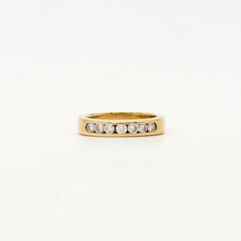 K&ouml;nnte beinhalten: Ein Goldring mit einer Reihe kleiner, klarer Diamanten.