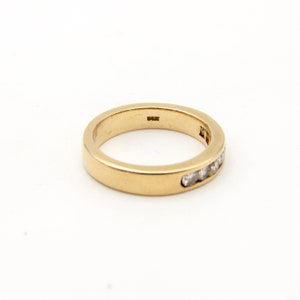 K&ouml;nnte beinhalten: Ein Goldband mit einer Reihe kleiner Diamanten, die in das Metall gefasst sind.