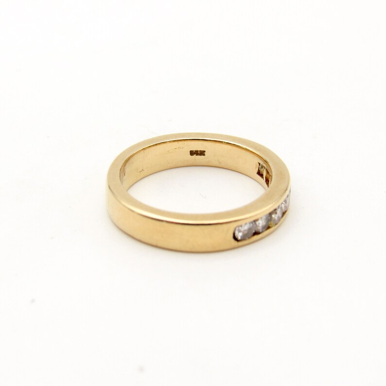 K&ouml;nnte beinhalten: Ein Goldband mit einer Reihe kleiner Diamanten, die in das Metall gefasst sind.