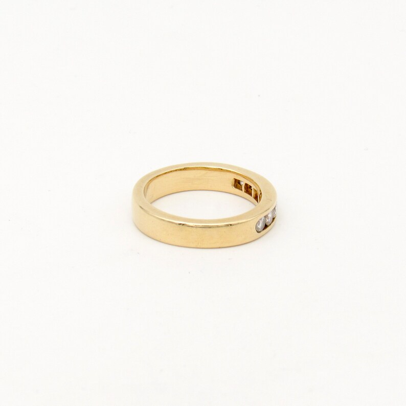 K&ouml;nnte beinhalten: Ein d&uuml;nner Goldring mit einer Reihe kleiner Diamanten, die in das Metall gefasst sind.