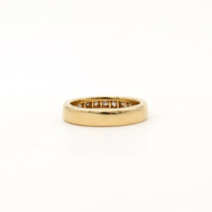 K&ouml;nnte beinhalten: Ein Goldring mit einer Reihe kleiner Diamanten, die in der Mitte eingesetzt sind.