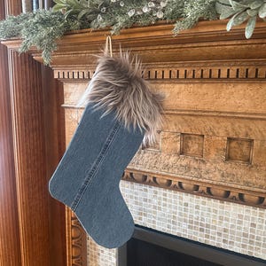 May include: A blue denim stocking with a brown and white faux fur cuff hanging on a fireplace mantel.