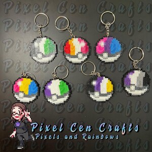 May include: Seven colorful Pokeball keychains made with perler beads. Each keychain features a different color combination of the Pokeball. The keychains are hanging from silver keyrings. The image includes the text "Pixel Cen Crafts" and "Pixels and Rainbows".