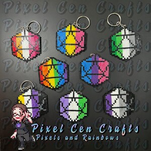 May include: Eight hexagonal beaded keychains with different pride flag designs. The keychains are made of colorful plastic beads and feature a variety of pride flags, including the rainbow, bisexual, transgender, and genderfluid flags. The keychains are arranged in a circle on a black background. The text "Pixel Cen Crafts" and "Pixels and Rainbows" is visible at the bottom of the image.