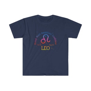 Op de afbeelding: Donkerblauw T-shirt met een kleurrijk astrologisch symbool voor Leeuw. Het symbool is omringd door de woorden "Trots, Gedurfd, Ambitieus, Zelfverzekerd" en de data "Jul 23" en "Aug 22".