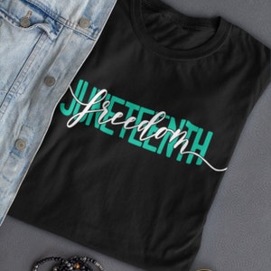 May include: Black t-shirt with the words "Juneteenth Freedom" written in teal green.
