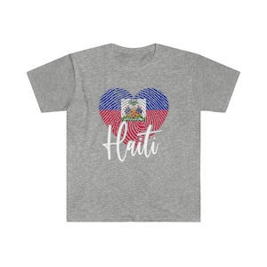 Op de afbeelding: Grijs T-shirt met een vingerafdruk-hartontwerp met de Ha&iuml;tiaanse vlag en het woord "Ha&iuml;ti" in witte letters.