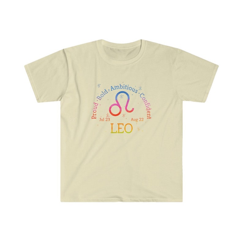 Op de afbeelding: Een lichtgeel T-shirt met een kleurrijk Leeuw-sterrenbeeld en de tekst "Trots. Gedurfd. Ambitieus. Zelfverzekerd. 23 juli - 22 augustus. LEEUW".