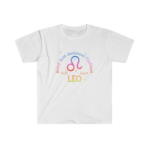 Op de afbeelding: Wit T-shirt met een kleurrijk Leeuw-sterrenbeeld, de data van 23 juli tot 22 augustus en de woorden "Trots. Gedurfd. Ambitieus. Zelfverzekerd."
