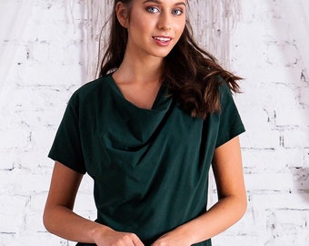 Puede incluir: Una blusa de cuello de pico verde oscuro de manga corta y corte holgado. La blusa está hecha de una tela suave y cómoda y tiene un estilo casual y sin esfuerzo.