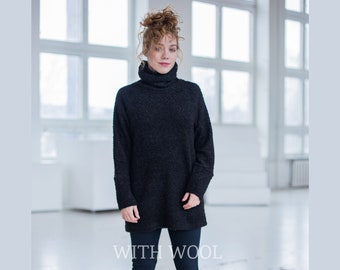 May include: A black turtleneck sweater with a fuzzy texture. The sweater is long and loose fitting. The model is wearing black pants and the text "WITH WOOL" is visible at the bottom of the image.