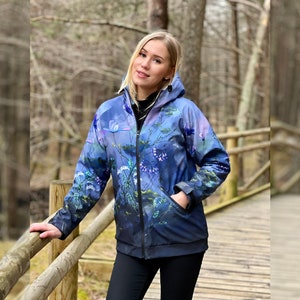 May include: A blue and purple floral print jacket with a zipper closure and a hood. The jacket has a relaxed fit and is made of a lightweight fabric.
