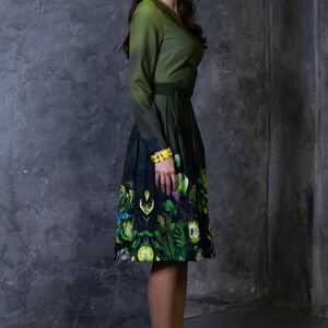 May include: A woman wearing a green dress with a floral print and yellow shoes. The dress has a fitted bodice and a full skirt.