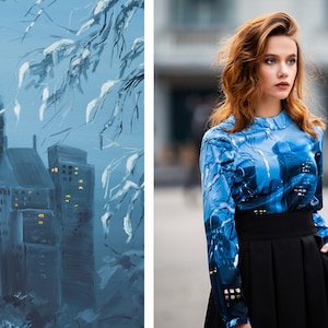 K&ouml;nnte beinhalten: Eine blaue Bluse mit einem Stadtbild-Druck. Die Bluse hat lange &Auml;rmel und einen hohen Ausschnitt. Das Model tr&auml;gt einen schwarzen Rock.