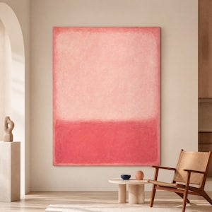 Könnte beinhalten: Großes rechteckiges abstraktes Gemälde in Rosa- und Rottönen. Das Kunstwerk hängt an einer neutralfarbenen Wand. Der Raum umfasst einen Holzstuhl, einen kleinen Tisch und dekorative Objekte, was eine minimalistische Ästhetik schafft.