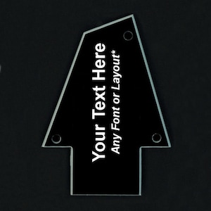 May include: Black guitar headstock plate with white text that says "Your Text Here Any Font or Layout*"