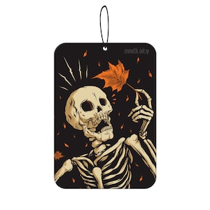 May include: A black and white illustration of a skeleton holding an orange leaf. The skeleton is wearing a black background with orange leaves scattered around it. The text "seventh.ink" is in the top right corner of the image.