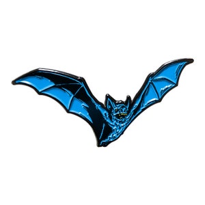 May include: A blue and black enamel pin of a bat with its wings spread out. The bat has a menacing expression with sharp teeth.