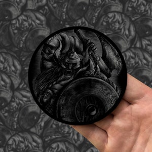 May include: Black and white illustration of a Viking warrior holding an axe and shield. The warrior is wearing a horned helmet and has a fierce expression on his face.