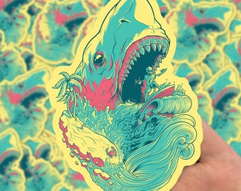 May include: A sticker featuring a colorful illustration of a shark with its mouth open, a surfer riding a wave inside the shark's mouth, and a palm tree on a small island.