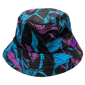 May include: A black bucket hat with a purple and blue bat print. The hat has a wide brim and a flat crown.
