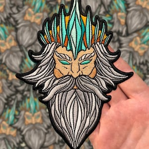 May include: Embroidered patch featuring a detailed depiction of a mythical figure with a long white beard, a crown of ice and a stern expression.