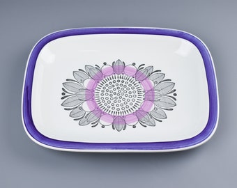May include: A white rectangular serving dish with a purple rim and a pink and black floral design in the center.