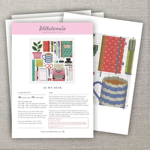 May include: A cross stitch pattern for a colorful illustration of a desk with a typewriter, coffee cup, pencils, and other office supplies. The pattern is titled "At My Desk" and includes instructions for stitching.