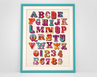 May include: A framed cross-stitch alphabet and number chart. The letters and numbers are in a colorful, circus-style font, with a variety of colors including red, orange, blue, and green. The frame is a teal color, and the background is a light beige.