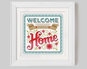 May include: White framed cross-stitch embroidery with a teal, brown, and red color scheme. The embroidery reads "Welcome to our Home" with floral accents.