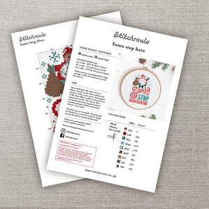 May include: Cross stitch pattern for a Santa Stop Here design. The pattern includes a color chart with DMC and Anchor thread numbers. The finished design is 4.5 inches wide by 7 inches high.