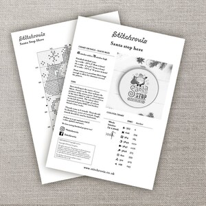 May include: A black and white cross stitch pattern for a Santa Stop Here design. The pattern includes a Santa Claus character with a red hat and beard, a Christmas tree, and the text "Santa Stop Here". The pattern is 45 stitches wide and 70 stitches high.