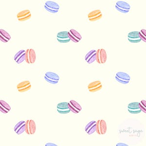 Pode incluir: Um padrão sem costura que apresenta ilustrações em aquarela de macarons em tons pastel. Os macarons estão dispostos em um padrão repetitivo sobre um fundo branco. O padrão inclui macarons em tons de roxo, azul, verde e amarelo.