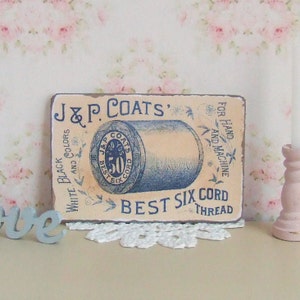 May include: Vintage J&P. Coats Best Six Cord Thread label with a spool of thread in blue and white. The label is printed on a cream background with black and white text. The text reads "J&P. Coats Best Six Cord Thread" and "White Black and Colors" and "For Hand and Machine".