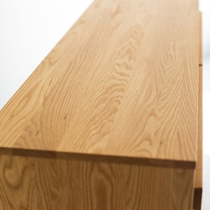 May include: A wooden dresser with a light brown finish. The dresser has four drawers and a smooth, flat top.