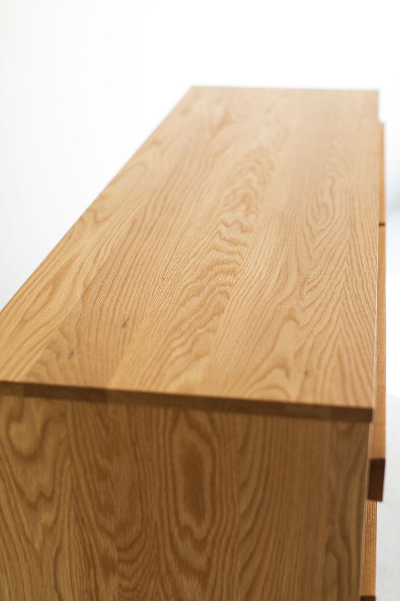 May include: A wooden dresser with a light brown finish. The dresser has four drawers and a smooth, flat top.