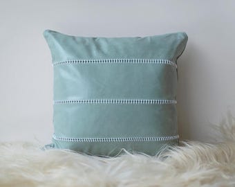 Puede incluir: Una almohada de color azul claro con costuras blancas. La almohada tiene un tejido suave y texturizado y es perfecta para añadir un toque de color a cualquier habitación.