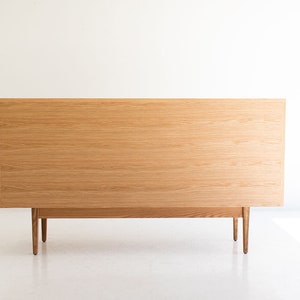 May include: A light wood dresser with four legs and a simple design.