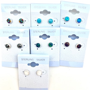 May include: Assortment of sterling silver stud earrings with various colored stones. The earrings are displayed on white cards with the words "Sterling Silver" printed on them.