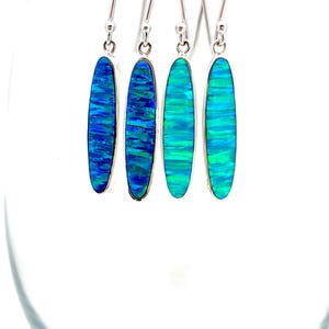May include: Four pairs of silver dangle earrings with oval-shaped blue and green opal stones.