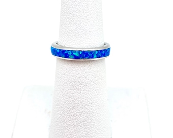 Pode incluir: Um anel de banda de prata com uma fina incrustação de opala azul.