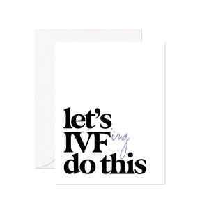May include: A white greeting card with a matching envelope. The card features the phrase "let's IVF do this" in a bold, black font, with "IVF" in a larger size and "ing" in a light purple color.