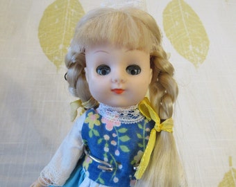 Blonde pop met blauwe ogen in mooie folk-jurk en mutscollectie Pop gemaakt in Hong Kong