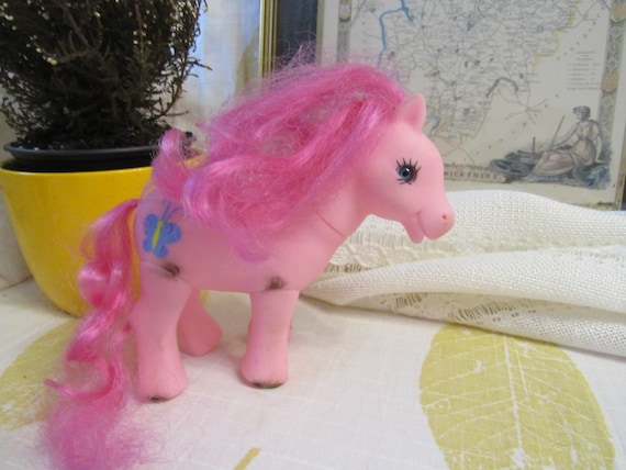 Poney rose avec des cheveux rose vif, des yeux bleus et un poney