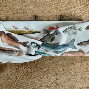 May include: A white headband with a colorful fish print. The headband is made of a soft, stretchy fabric and is perfect for keeping hair out of your face.