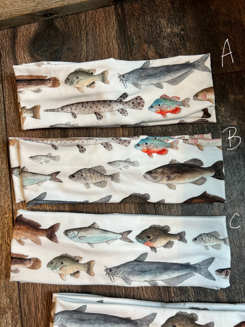 May include: Three white headbands with a variety of colorful fish printed on them. The headbands are labeled A, B, and C.